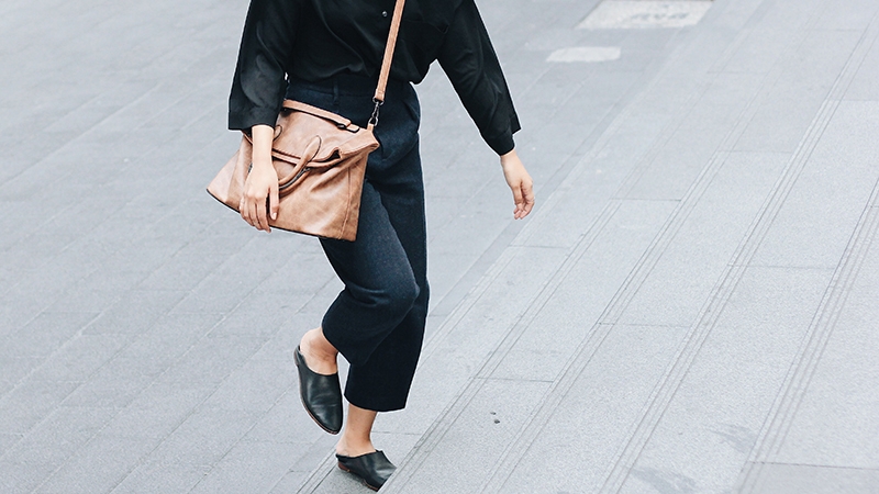 woman in black with beige handbag