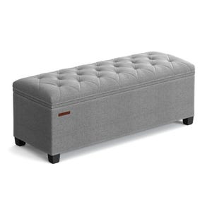 A gray, tufted, rectangular storage ottoman with dark wooden legs, measuring 43 inches in length.