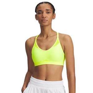 A person wearing a bright yellow sports bra and white shorts. The sports bra has a racerback design.