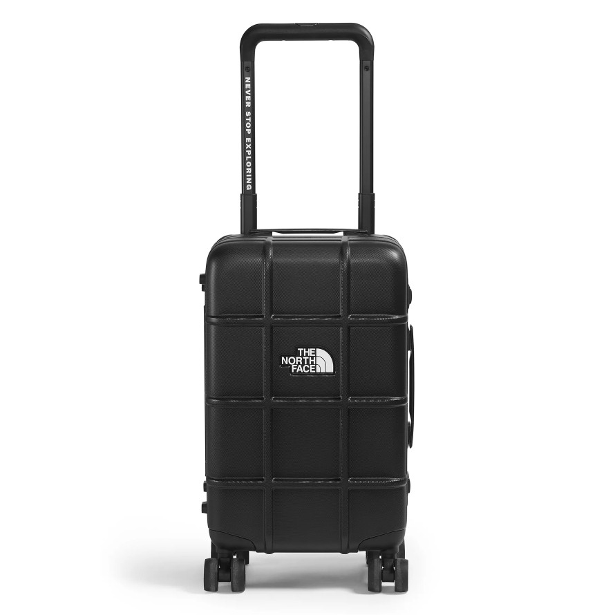 A black rolling suitcase from The North Face with a grid pattern, featuring a telescopic handle labeled \“Never Stop Exploring\“ and four wheels for easy mobility.
