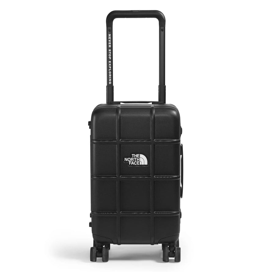 A black rolling suitcase from The North Face with a grid pattern, featuring a telescopic handle labeled \“Never Stop Exploring\“ and four wheels for easy mobility.