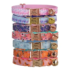 A set of colorful pet collars with floral patterns and engraved buckle tags, each displaying a name and phone number. The collars also feature small bells.