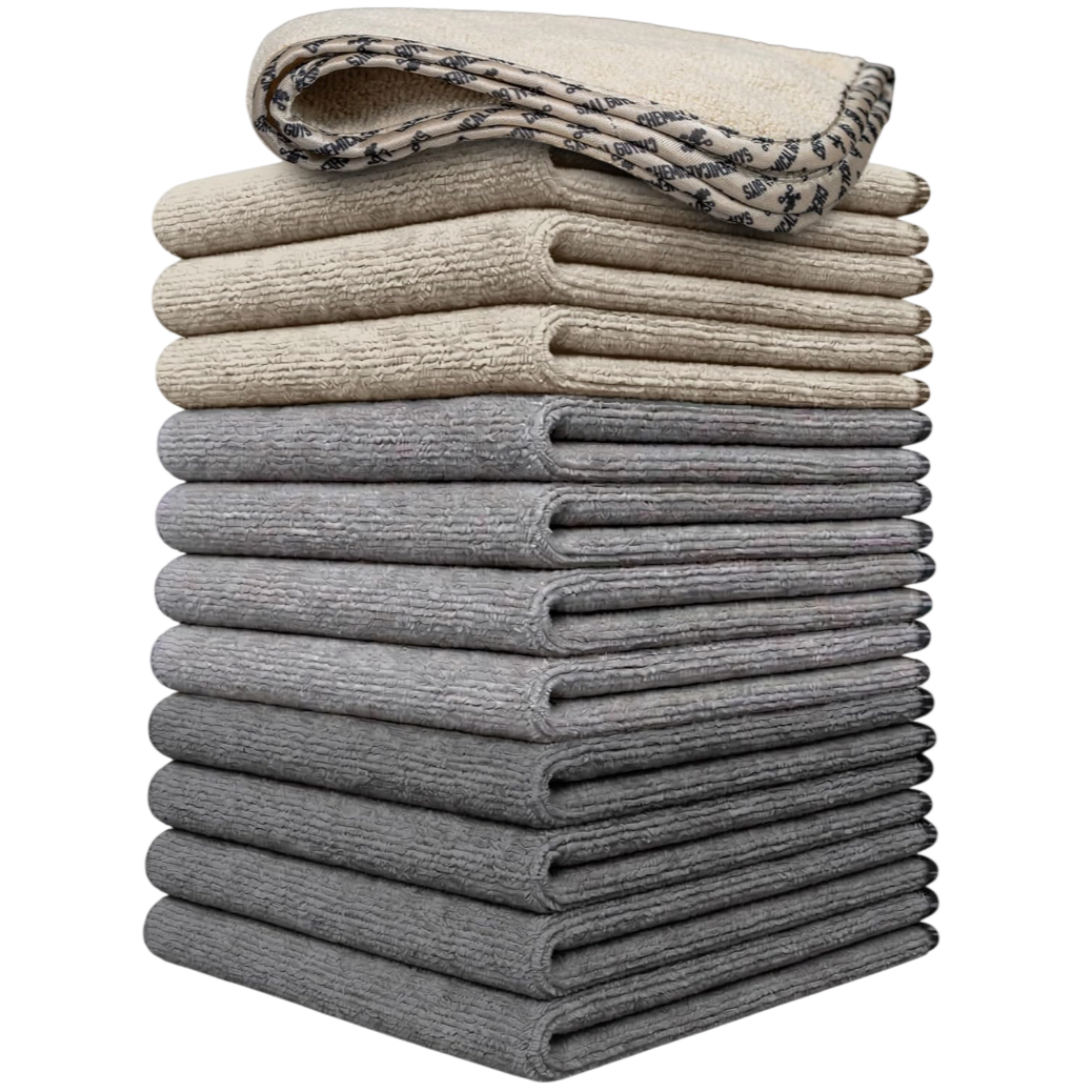 A stack of beige and gray microfiber towels is shown, with the top towel featuring a patterned edge.