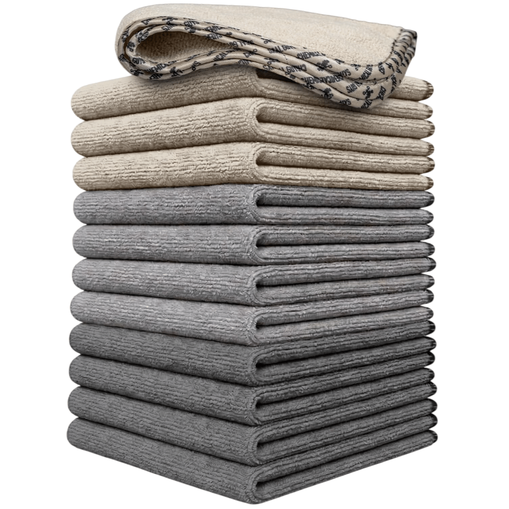 A stack of beige and gray microfiber towels is shown, with the top towel featuring a patterned edge.
