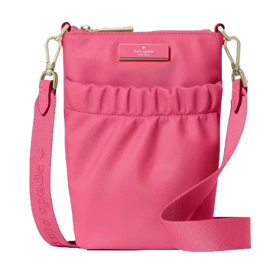 A pink crossbody bag with a zip closure and adjustable strap, featuring the Kate Spade logo on the front.