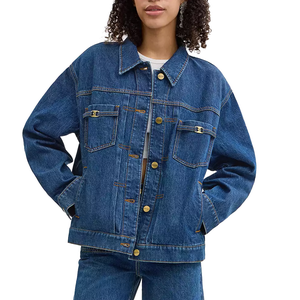 A person is wearing a blue denim jacket with a relaxed fit, featuring button closures and front pockets, paired with matching denim jeans.