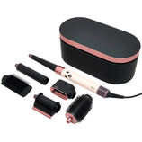 Dyson hair styling tool set includes a main device and multiple attachments for curling, smoothing, and volumizing. The set comes in a black and rose gold design with a storage case.