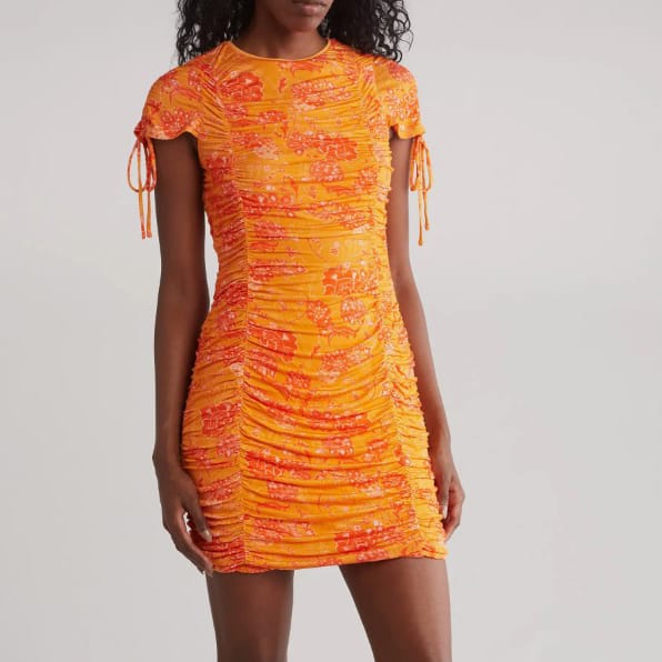 A short, ruched orange dress with a patterned design and drawstring details on the sleeves.
