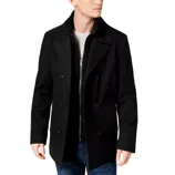 A man is wearing a classic black double-breasted pea coat over a textured sweater, paired with jeans.