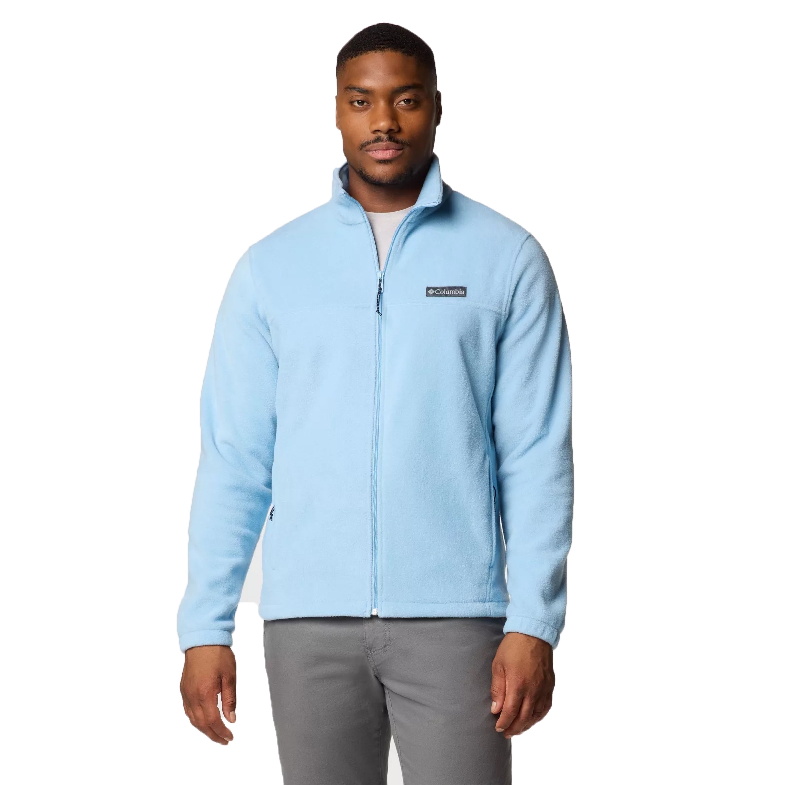 A man is wearing a light blue Columbia fleece jacket with a front zipper, complemented by gray pants.