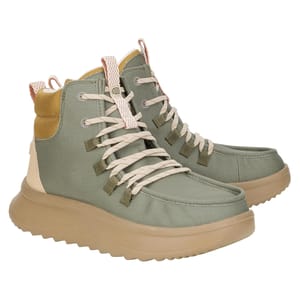 Hey Dude Wendy Peak Booties are high-top casual shoes with a sage green canvas upper, beige laces, and a cushioned beige sole. They feature a pull tab for easy wear and mustard yellow accents at the heel.