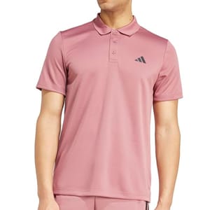 Adidas Men's Essentials Polo Shirt is pink with a minimalist design, featuring a small black Adidas logo on the chest, a three-button placket, and short sleeves.