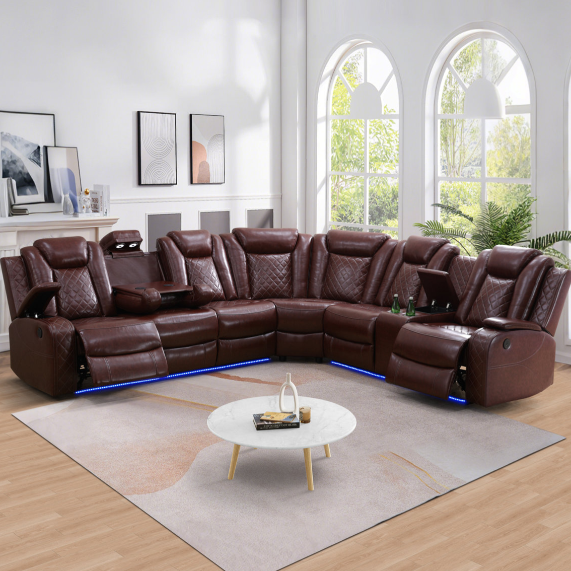 Brown leather sectional sofa with built-in recliners, cup holders, and LED lighting, set in a living room with large arched windows and a round marble coffee table.