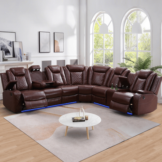 Brown leather sectional sofa with built-in recliners, cup holders, and LED lighting, set in a living room with large arched windows and a round marble coffee table.