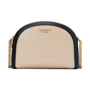 A half-moon shaped Kate Spade New York leather crossbody bag with a beige front, black trim, and a gold-tone chain strap.