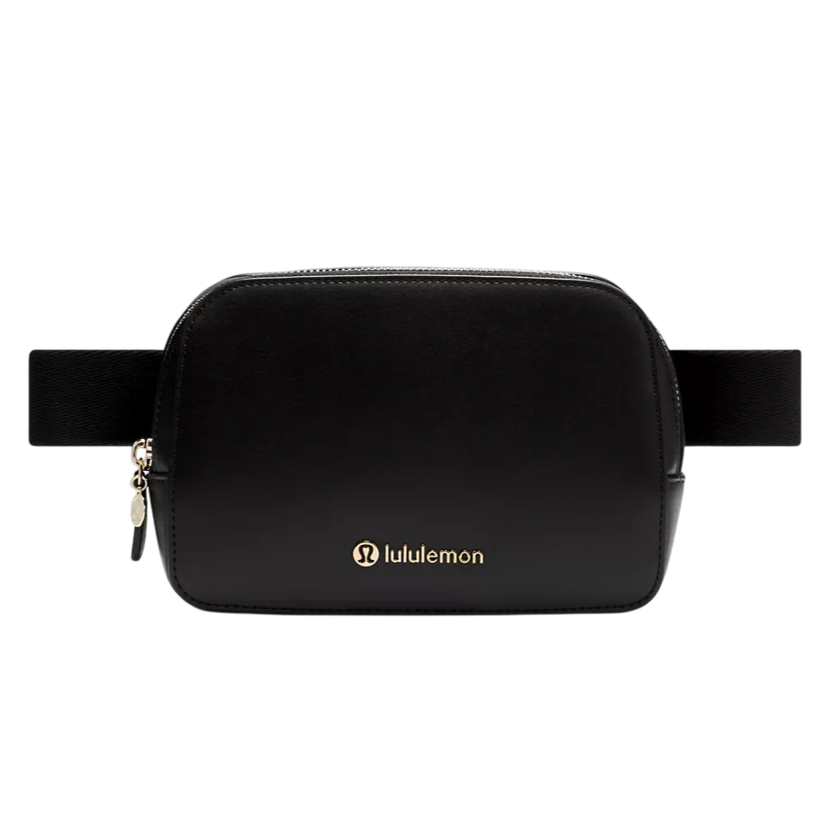 A black Lululemon belt bag with a gold zipper and logo, featuring a wide, adjustable strap.