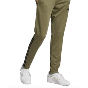 Olive green track pants with black stripes on the side and white sneakers, both featuring the Adidas logo.