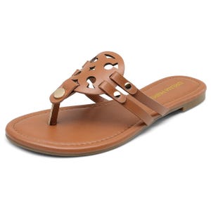 Brown leather thong sandal with decorative cut-out design and metallic rivets, featuring a flat sole.