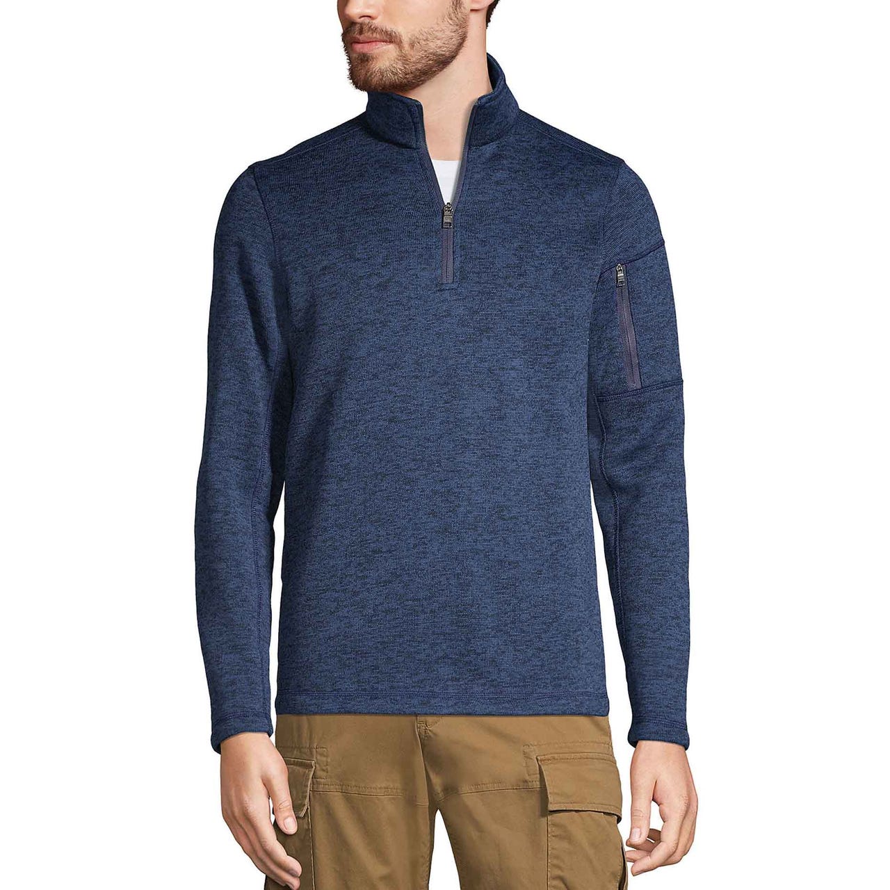 A man is wearing a blue quarter-zip pullover paired with brown cargo pants. The pullover has a zippered pocket on the left sleeve.