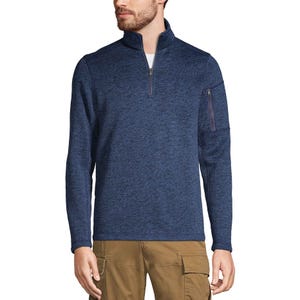 A man is wearing a blue quarter-zip pullover paired with brown cargo pants. The pullover has a zippered pocket on the left sleeve.