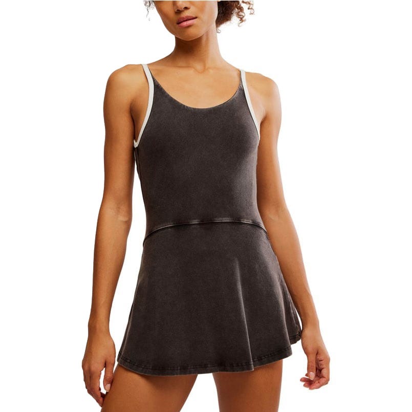 A woman models a sleeveless black dress with white trim and a flared skirt, showcasing a sporty and casual style.