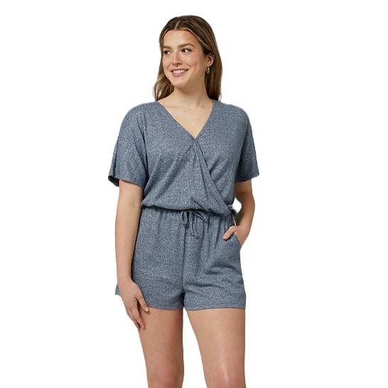 A woman is wearing a blue short-sleeve romper with a V-neck and drawstring waist, featuring pockets.