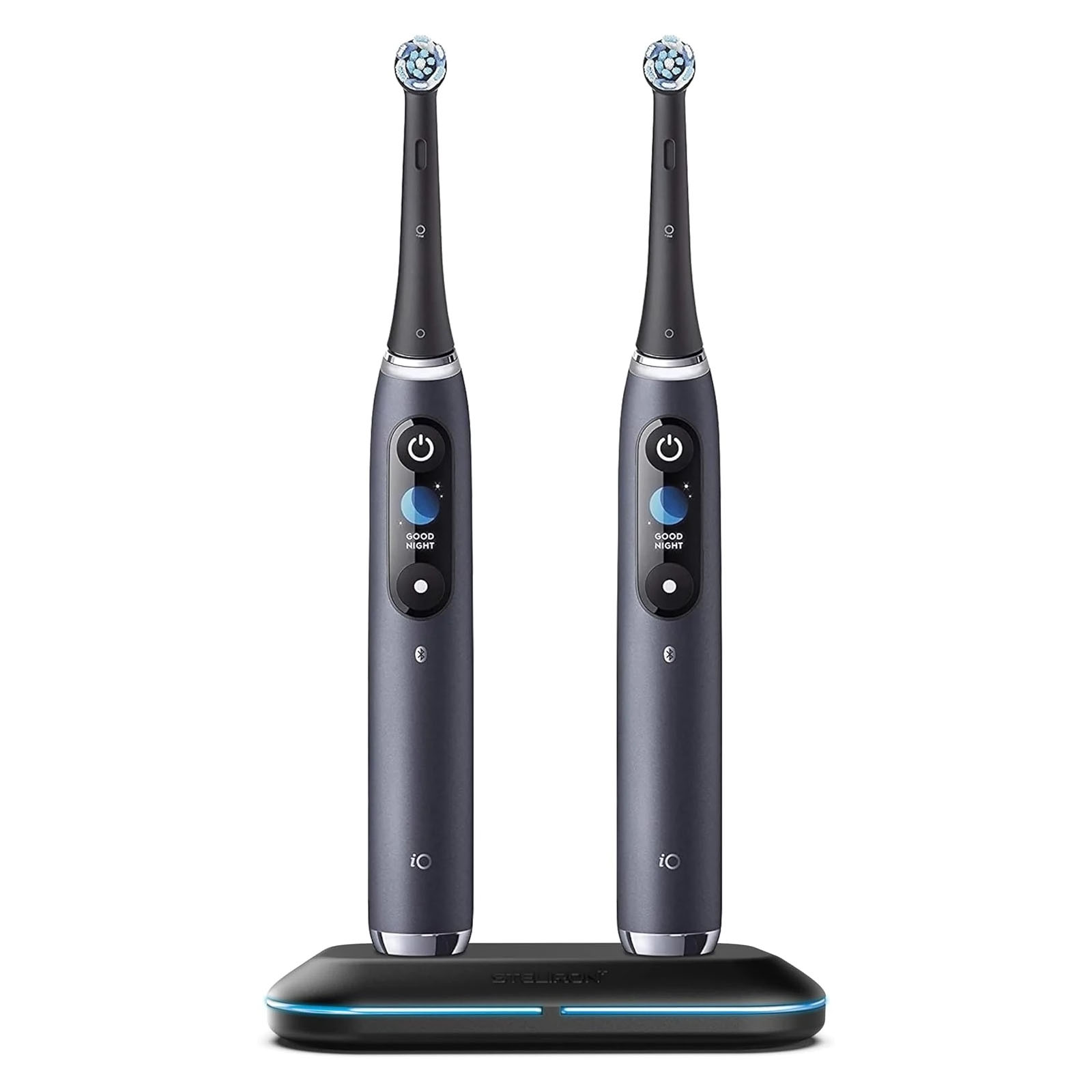 Two electric toothbrushes with round brush heads are standing on a charging base.
