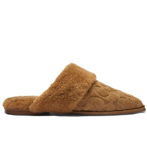 A tan slip-on mule with a fluffy shearling collar and a textured pattern on the upper.