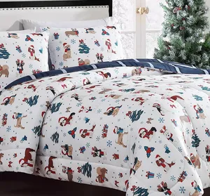 Festive bedding set with a holiday theme, featuring illustrations of dogs, Christmas trees, gifts, and snowflakes in red, blue, and brown on white fabric, complemented by navy striped sheets.