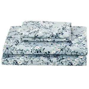 A set of pale blue floral bed sheets, including a flat sheet, fitted sheet, and pillowcase with a delicate white and dark blue flower pattern.