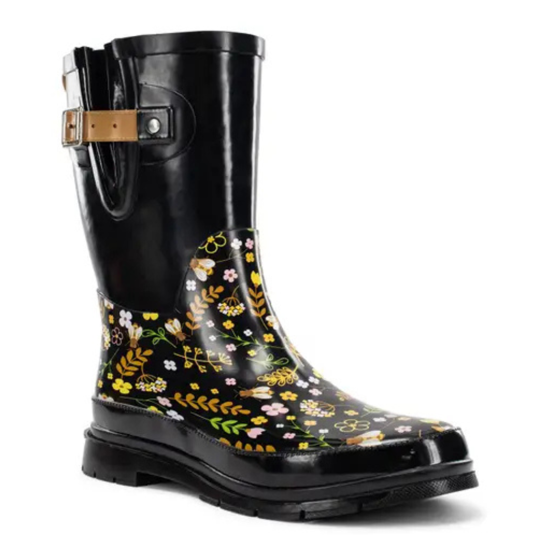 Western Chief Sweet Bees Rain Boots feature a black base with a floral and bee design, including yellow and pink flowers. They come with a side buckle and a durable rubber sole for wet conditions.