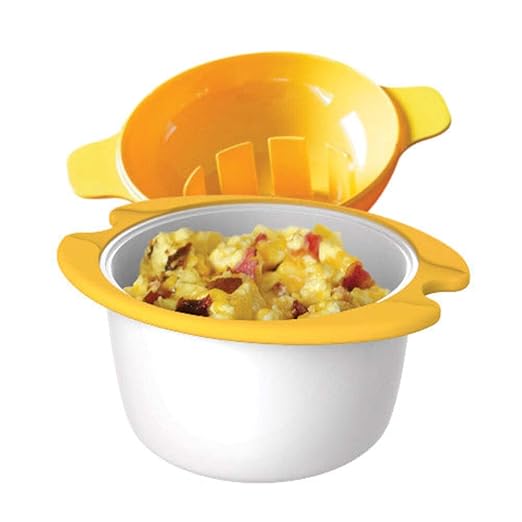 A microwave egg cooker with a yellow lid and handles, containing scrambled eggs mixed with bacon pieces.