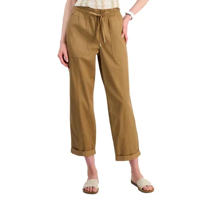 Tan drawstring pants with front patch pockets, cuffed hems, and a relaxed fit, paired with white textured slide sandals.