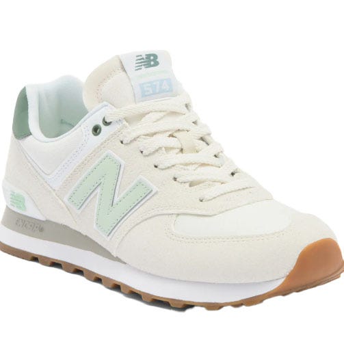 A light beige New Balance 574 sneaker with mint green accents and a gum sole, featuring the iconic \“N\“ logo and \“574\“ branding on the tongue.