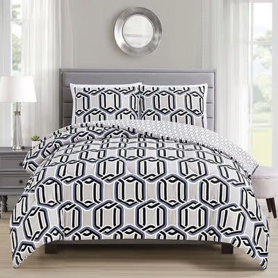 A bed with a geometric-patterned comforter set including pillows, in a room with a round mirror on the wall.