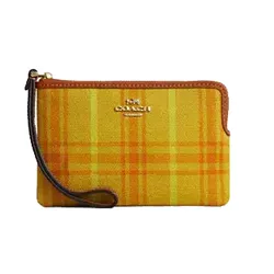 A yellow zippered wristlet with orange plaid pattern and brown trim featuring a gold Coach logo.