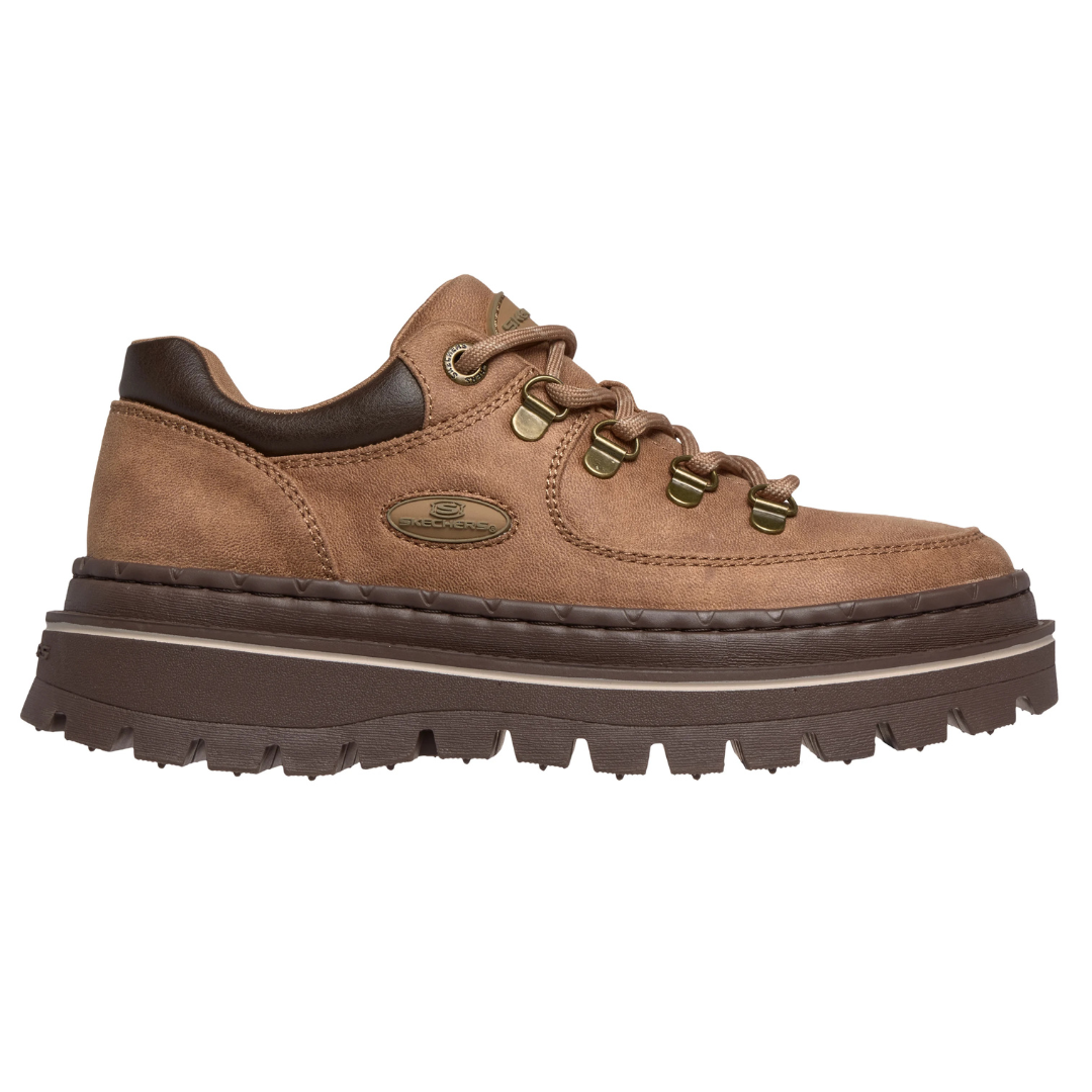A brown Skechers lace-up shoe with a chunky sole, metal eyelets, and a side logo, designed for a rugged look.