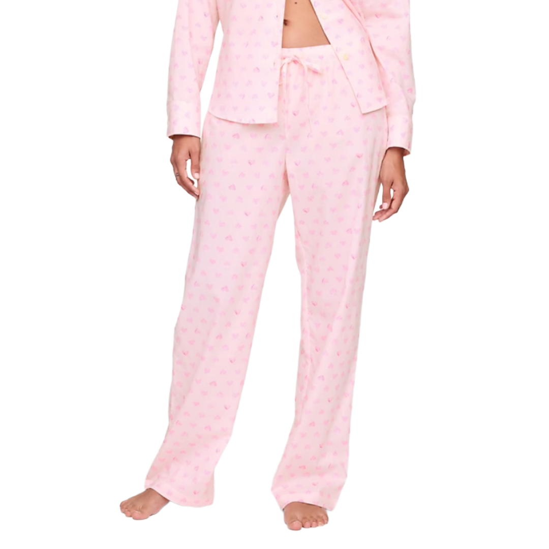 Light pink pajama set with a small heart pattern, featuring a long-sleeve button-up shirt and drawstring pants.