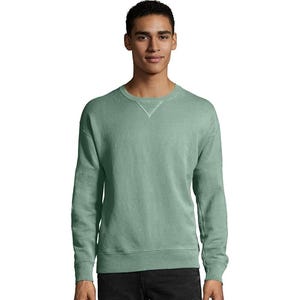 A man wearing a light green Hanes fleece sweatshirt with a crew neck and ribbed cuffs. The sweatshirt has a relaxed fit and a V-shaped stitch detail at the neckline.