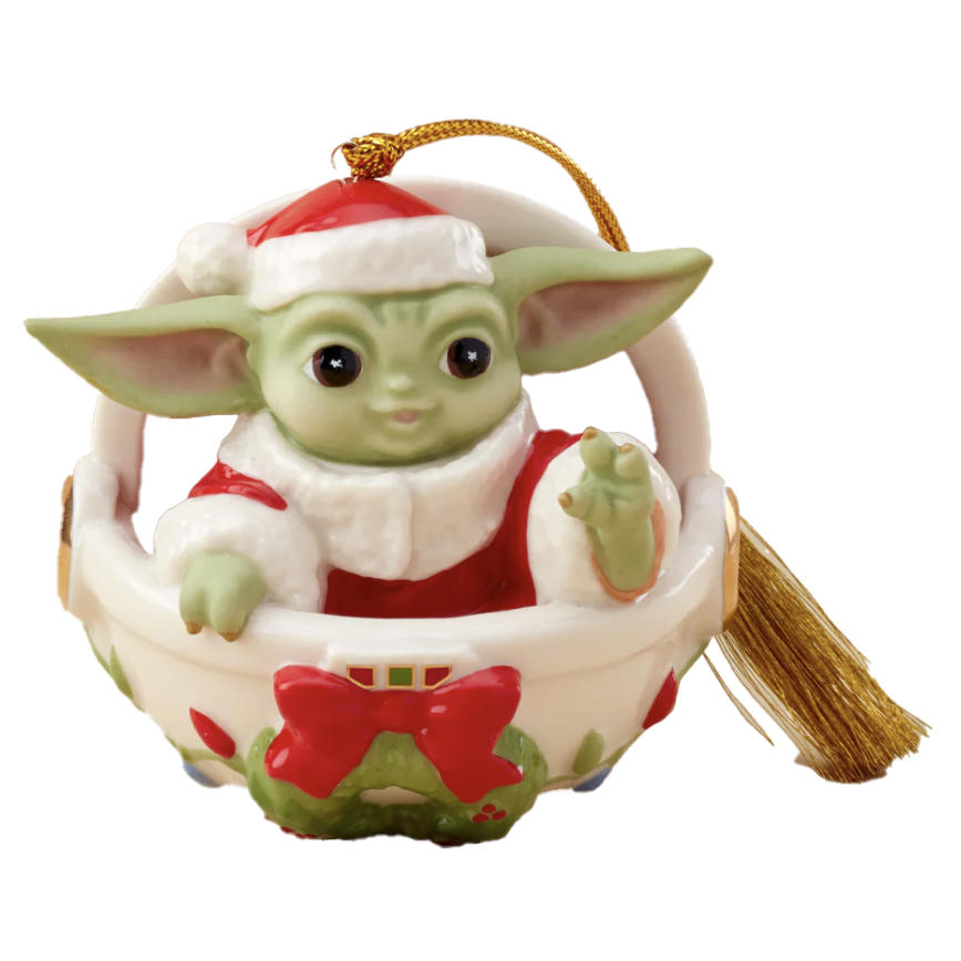 A Christmas ornament featuring a character dressed in a Santa suit with a red hat, seated in a basket adorned with a red bow, and a gold tassel for hanging.