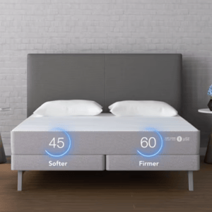 A split mattress is shown with adjustable firmness levels, displaying a softer side at 45 and a firmer side at 60, alongside two bedside tables with lighting and decor.