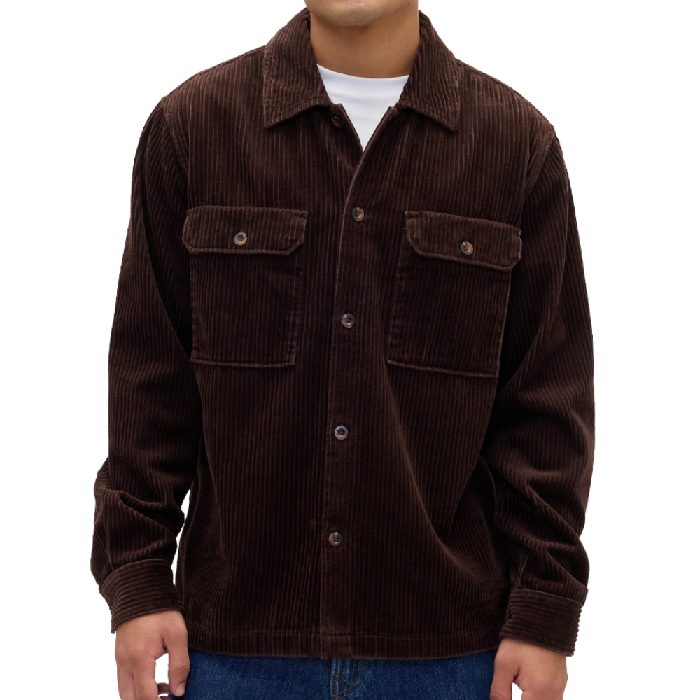 Dark brown corduroy button-up shirt with front pockets and collar, worn over a white shirt, paired with blue jeans.