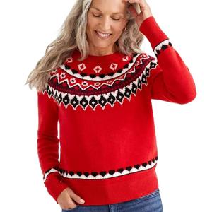 A red Fair Isle sweater with black and white geometric patterns around the yoke, cuffs, and hem. The garment features long sleeves and a classic fit, paired with jeans.