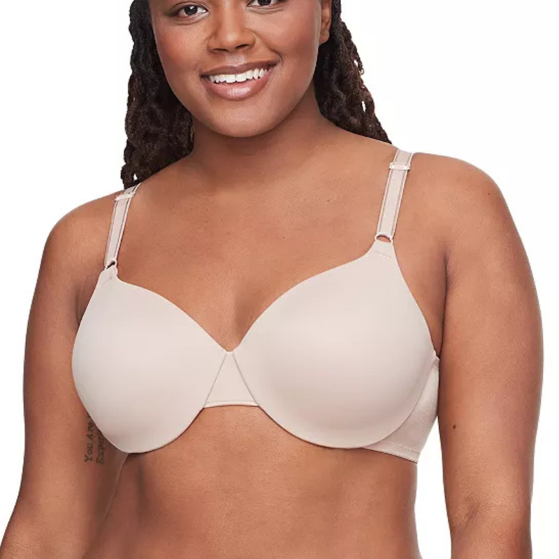 A woman is wearing a seamless, nude-colored, full-coverage bra with adjustable straps designed for comfort and support.