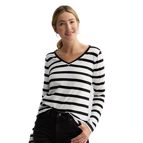 A woman is wearing a long-sleeve, black-and-white striped V-neck shirt paired with black pants.