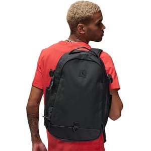 A black Nike Air Jordan Franchise Backpack is shown, featuring a sleek design with the Jumpman logo. It has multiple straps and pockets, combined with a modern look, ideal for carrying essentials.