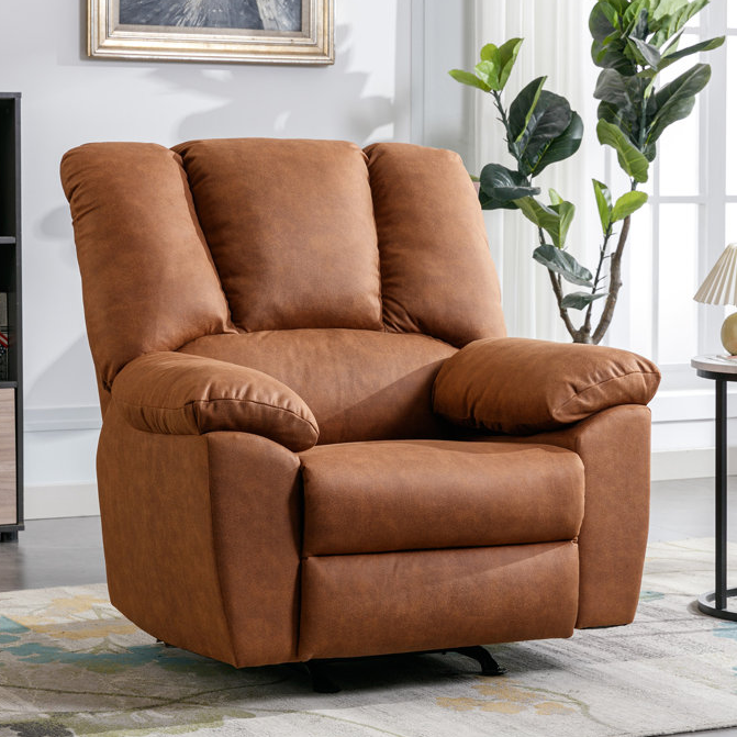 A brown recliner chair with plush cushions is placed on a rug in a cozy room setting, accompanied by a potted plant and a small side table with a lamp.