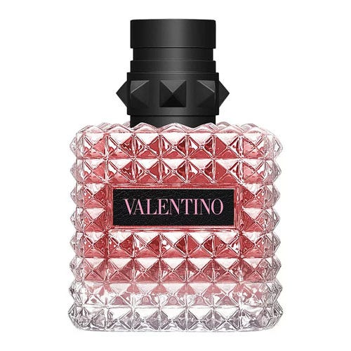A pink glass bottle with a studded texture and a black cap, labeled \“Valentino.\“