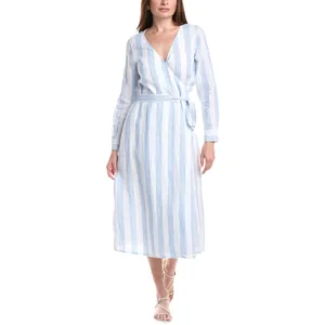 A woman wears a blue and white striped wrap dress with long sleeves and a tie waist, paired with white strappy sandals.