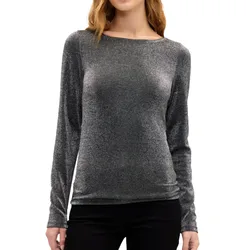 A woman wearing a silver long-sleeved, metallic shimmer top paired with black pants.